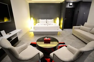 a bedroom with a bed and a table and chairs at Pumeria Resort Phuket - SHA Plus in Bang Tao Beach