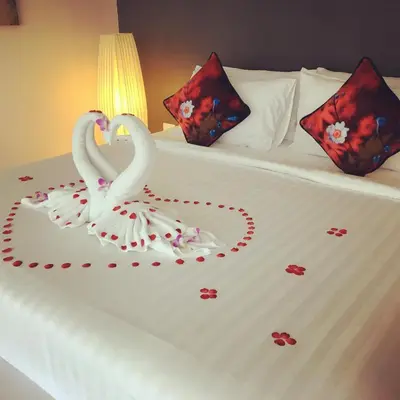 two swans are sitting on a bed with hearts at Pumeria Resort Phuket - SHA Plus in Bang Tao Beach