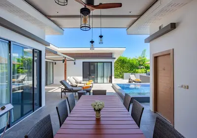 a dining room with a table and chairs and a pool at CASABAY Luxury Pool Villas by STAY in Rawai Beach