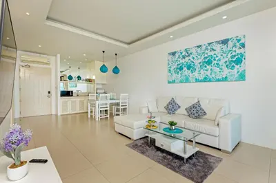 a living room with a couch and a table at Amala Grand Bleu Resort Hilltops - SHA in Kamala Beach