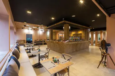 a restaurant with tables and chairs and a bar at Amala Grand Bleu Resort Hilltops - SHA in Kamala Beach