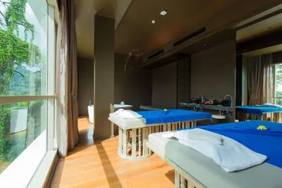 two beds in a room with a large window at Wyndham Grand Phuket Kalim Bay in Patong Beach