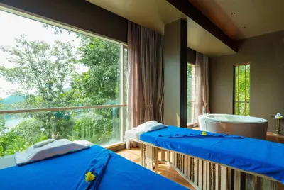 two beds in a room with a large window at Wyndham Grand Phuket Kalim Bay in Patong Beach