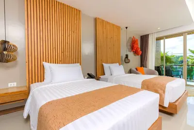 a hotel room with two beds and a window at Wyndham Grand Phuket Kalim Bay in Patong Beach
