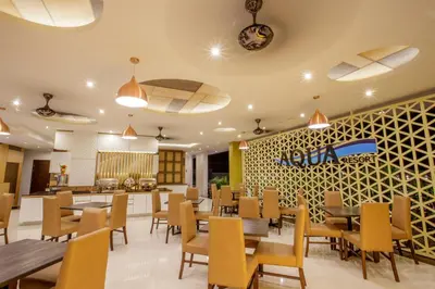 a dining room with tables and chairs and a restaurant at Aqua Resort Phuket - Near Beach and Chalong Pier in Rawai Beach