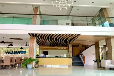a lobby of a building with a staircase and chairs at Aqua Resort Phuket - Near Beach and Chalong Pier in Rawai Beach