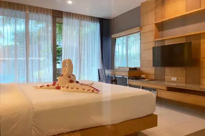 a bedroom with a bed with shoes on it at Aqua Resort Phuket - Near Beach and Chalong Pier in Rawai Beach