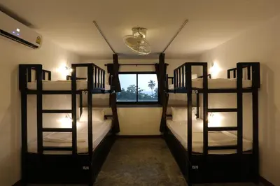 three bunk beds in a room with a window at Balcony Party Hostel - 18-40 in Ao Nang Beach