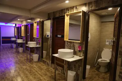 a bathroom with a row of sinks and toilets at Balcony Party Hostel - 18-40 in Ao Nang Beach