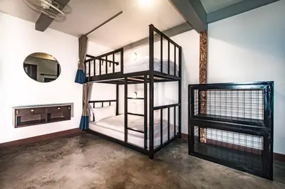 a room with two bunk beds and a mirror at Balcony Party Hostel - 18-40 in Ao Nang Beach