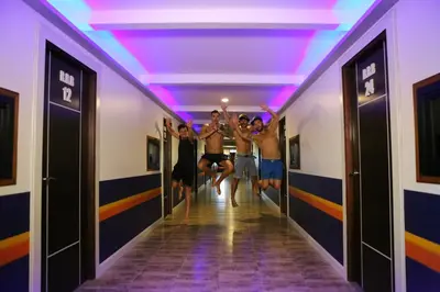 a group of men running down a hallway with their arms in the air at Balcony Party Hostel - 18-40 in Ao Nang Beach
