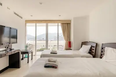 a hotel room with two beds and a flat screen tv at Andaman Sea View Apartment - Patong Beach in Patong Beach