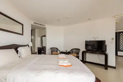 a bedroom with a large white bed and a flat screen tv at Andaman Sea View Apartment - Patong Beach in Patong Beach