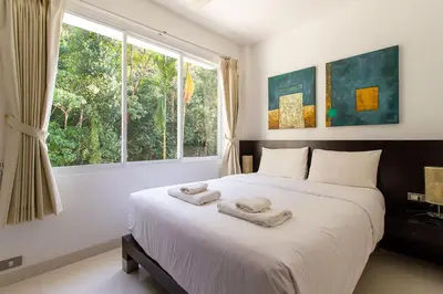 a bedroom with a large bed with two towels on it at Kamala Hills Serviced Apartments in Kamala Beach