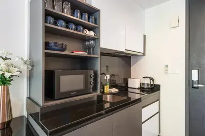 a kitchen with a microwave and a tv on a counter at The Deck Condominium Patong Beach in Patong Beach