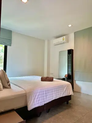 a bedroom with a bed and a large window at Sunset Bay View Phuket in Patong Beach