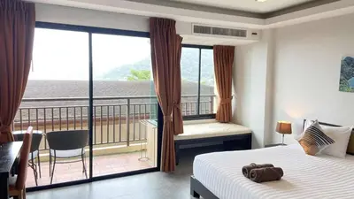 a hotel room with a bed and a balcony at Sunset Bay View Phuket in Patong Beach