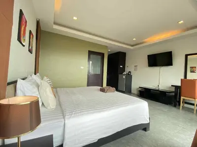 a hotel room with a large bed and a television at Sunset Bay View Phuket in Patong Beach