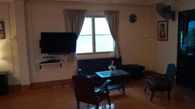 a living room with a table and a tv at Kata Apartment in Kata Beach