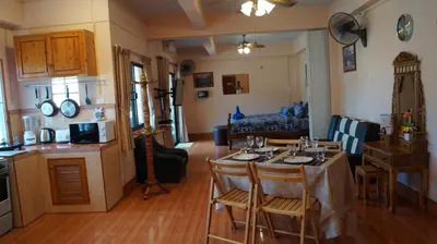 a kitchen and living room with a table and chairs at Kata Apartment in Kata Beach