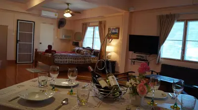 a dining room table with wine glasses on top of it at Kata Apartment in Kata Beach