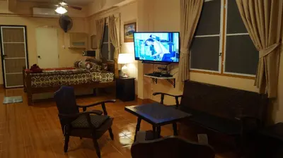 a living room with a television and a bed at Kata Apartment in Kata Beach