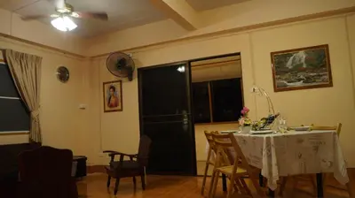 a dining room with a table and chairs and a window at Kata Apartment in Kata Beach