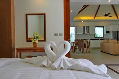 two swans made out of towels on top of a bed at Ya Nui Beach Villas in Rawai Beach
