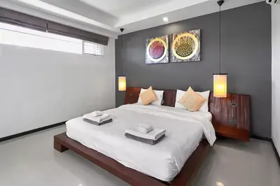 a bedroom with a large bed with two towels on it at Villa Oxygen - Bangtao Beach in Bang Tao Beach