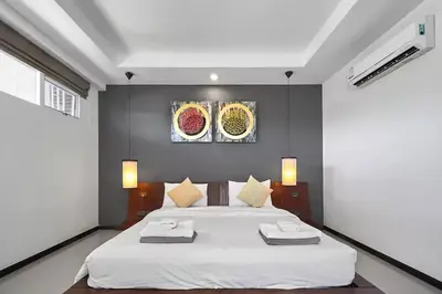 a bedroom with a bed with two towels on it at Villa Oxygen - Bangtao Beach in Bang Tao Beach