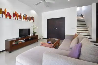 a living room with a couch and a tv at Villa Oxygen - Bangtao Beach in Bang Tao Beach