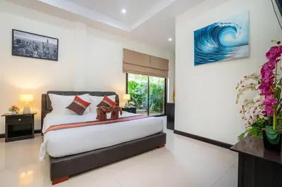 a bedroom with a bed and a large window at Boutique Resort Private Pool Villa - SHA Extra Plus in Thalang