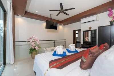 a bedroom with two beds and a ceiling fan at Boutique Resort Private Pool Villa - SHA Extra Plus in Thalang