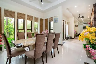 a dining room with a table and chairs and flowers at Boutique Resort Private Pool Villa - SHA Extra Plus in Thalang