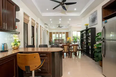 a kitchen with a counter and a dining room at Boutique Resort Private Pool Villa - SHA Extra Plus in Thalang