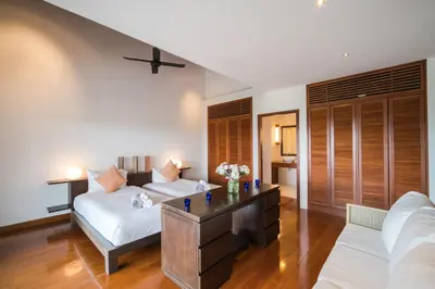 a living room with a couch and a table at Vichuda Hills by RESAVA in Layan Beach