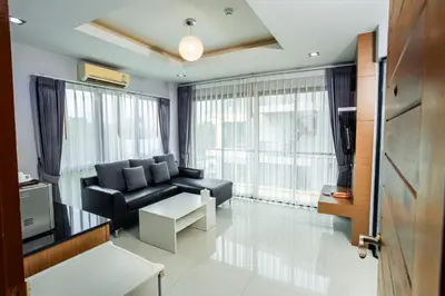 a living room with a black couch and a tv at The Lucky Beach Ao Nang in Ao Nang Beach