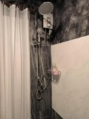 a shower in a bathroom with a shower curtain at Phi Phi Phu Chalet Resort in Phi Phi Don