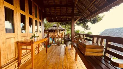 a porch of a house with a bench and a table at Phi Phi Phu Chalet Resort in Phi Phi Don