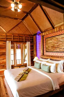 a bedroom with a large white bed in a room at Phi Phi Phu Chalet Resort in Phi Phi Don