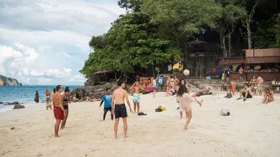 a group of people playing on a beach at K-Bunk AoNang Center in Ao Nang Beach