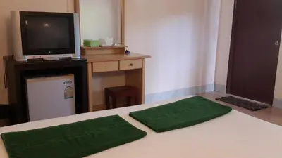 a room with a bed with two green pillows on it at Phi Phi View Point Resort in Phi Phi Don