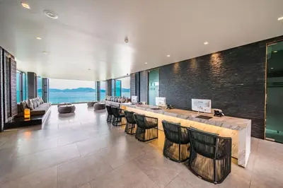 a lobby with a bar with chairs and a view at My Beach Resort Phuket, Panwa Beach in Panwa Beach