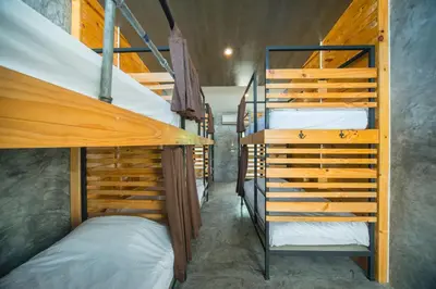 a room with two bunk beds and a staircase at ChillHub Hostel Phuket in Bang Tao Beach