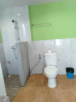 a bathroom with a toilet and a shower stall at Six Pack Cottage in Chalong