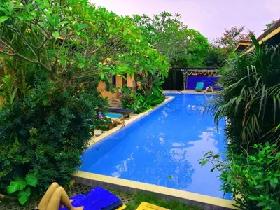 a swimming pool with blue water in a resort at Six Pack Cottage in Chalong