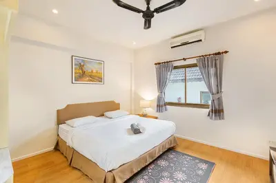 a bedroom with a large bed and a window at Happy Family Villa 2 in Chalong