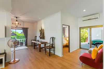 a living room with a red couch and a table at Happy Family Villa 2 in Chalong