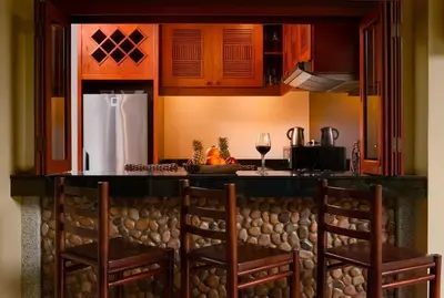a kitchen with a counter with chairs and a refrigerator at Villa Raas 3BR Private PoolNaiharn beach in Nai Harn Beach