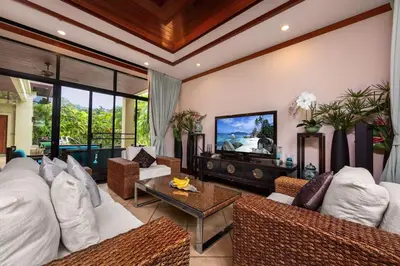 a living room with white furniture and a tv at Villa Raas 3BR Private PoolNaiharn beach in Nai Harn Beach